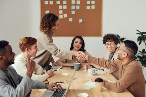 People greeting each other around a table